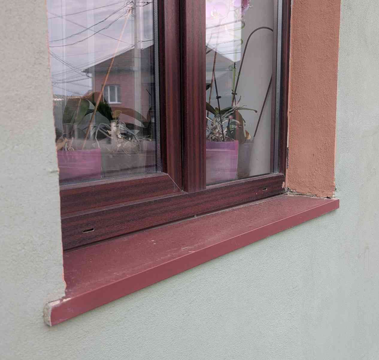 Glaf exterior din aluminiu extrudat de culoare vișinie, cu semne de uzură și etanșare degradată la contactul cu fațada